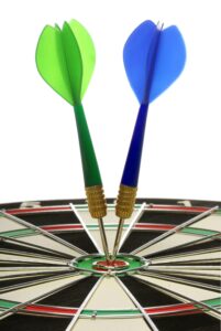 Eine Dartsscheibe, in der 2 Darts im Bullseye stecken, ein grüner und ein blauer Dart.